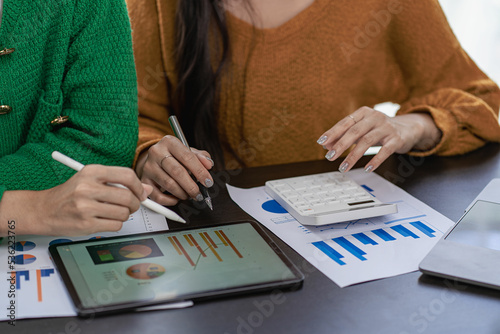 Businessman analyzing financial statistics displayed on a tablet screen. Business colleagues working and analyzing financial numbers on digital tablets.