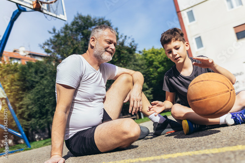 Father and his son enjoying together on basketball court.