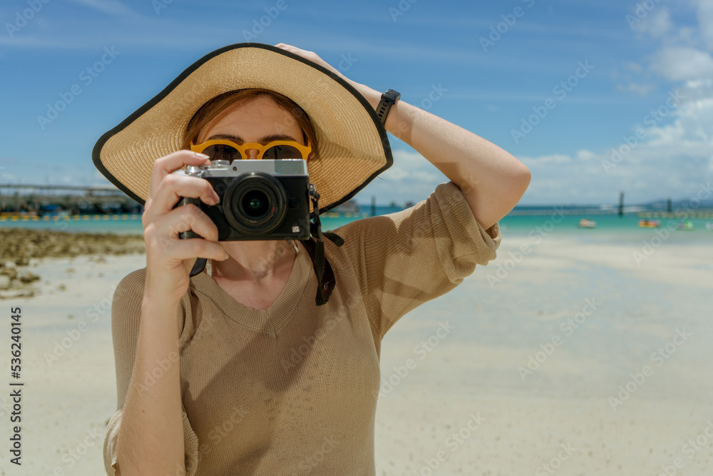 woman wearing sunglasses standing on the beach take a photo by digital camera with sunny day woman wearing sunglasses standing on the beach take a photo by digital camera with sunny day