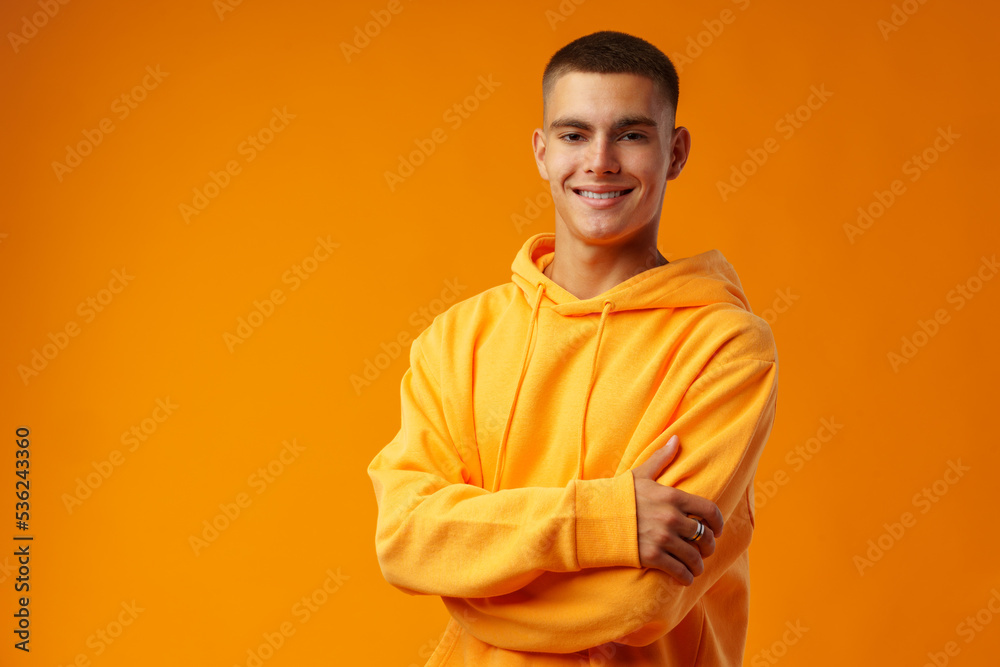 Fototapeta premium Happy smiling young man looking to camera over yellow background
