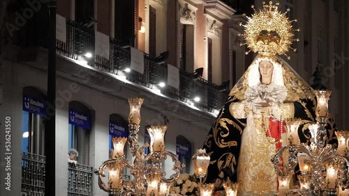 Close-up of procession carriage with Virgin Mary during Holy Week celebrations on Good Friday at Madrid, Spain. Figure is wearing a tunic with golden decoration and a golden crown. Beautiful image. photo