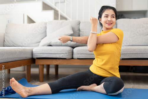 Attractive young woman doing yoga stretching yoga online at home. Self-isolation is beneficial. Healthy lifestyle concept