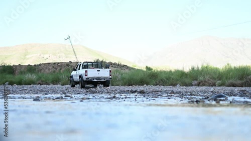 View Of Parked White Truck Across Flowing River In Balochistan. Low Angle Shot photo