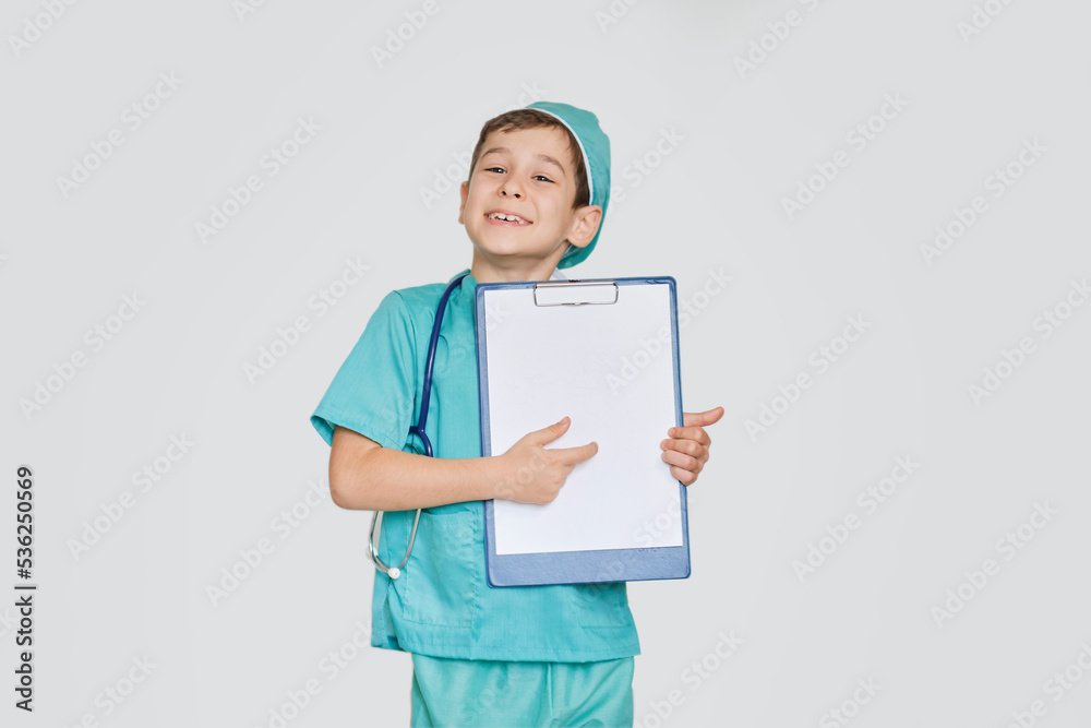 happy preschooler boy wearing medical uniform character holds clipboard and writing diagnosis. career concept. Little boy role playing doctor occupation. Young nurse image. happy preschooler boy wearing medical uniform character holds clipboard and writing diagnosis. career concept. Little boy role playing doctor occupation. Young nurse image.