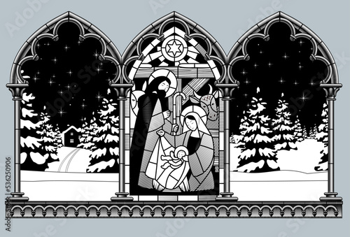 Engraved vintage drawing of gothic frame with a Stained glass window of the scene of the birth of Jesus Christ and night winter forest photo