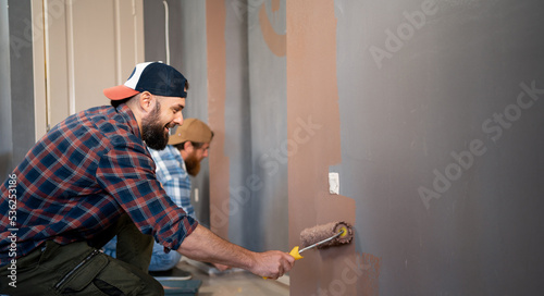 Canvas Print two bearded men with roller painting paint the walls making repairs