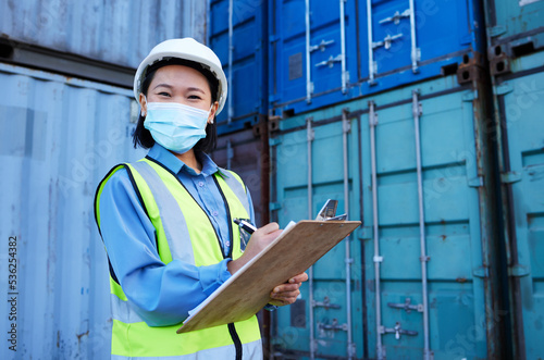 Container, covid 19 and engineer woman checklist planning cargo distribution, shipping and manufacturing logistics. Supply chain Asian manager or contractor face mask for safety and virus protection