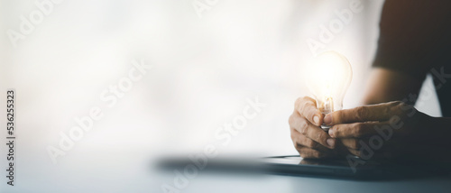 Standing woman holding glowing lamp, Creative new idea. Innovation, brainstorming, strategizing to make the business grow and be profitable. Concept execution, strategy planning and profit management.