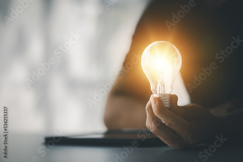 Standing woman holding glowing lamp, Creative new idea. Innovation, brainstorming, strategizing to make the business grow and be profitable. Concept execution, strategy planning and profit management.