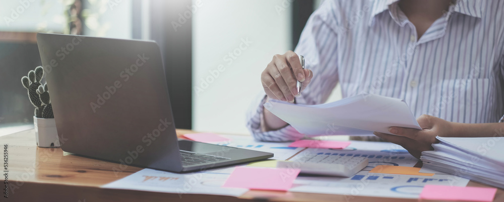 Business woman using calculator for do math finance on wooden desk in office and business working background, tax, accounting, statistics and analytic research concept Business woman using calculator for do math finance on wooden desk in office and business working background, tax, accounting, statistics and analytic research concept