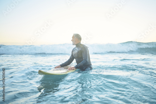 Photography Swimming, beach and old man in water surfing enjoying a summer holiday vacation his retirement in Los Angeles, USA
