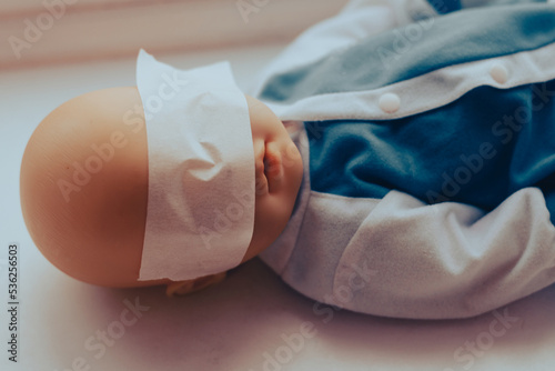 Fotografi baby doll with taped eyes. child abuse concept