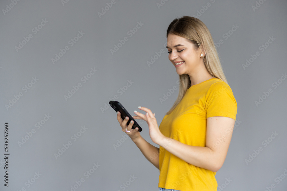 Young woman smiling while using phone isolated over white background Young woman smiling while using phone isolated over white background