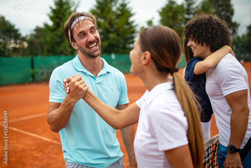 Group of tennis people players giving a handshake after a match