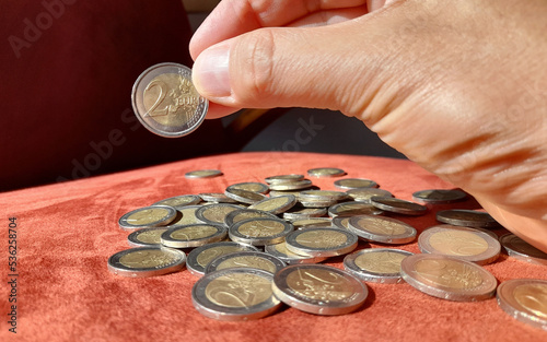 Moneta da 2 euro nelle mani di un uomo photo