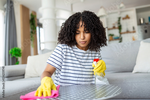 Woman cleaning and polishing the table with a spray detergent, housekeeping and hygiene concept