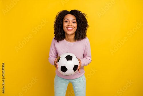 Photo of young cheerful lady catch throw ball competition game isolated over yellow color background © Tetiana