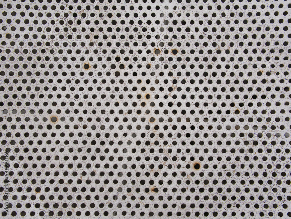 Metal with white painted surface, round black holes, weathered, rusty, abstract background, full frame