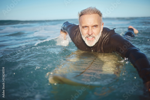 Water, beach and man surfing waves for adventure during retirement on holiday in ocean in summer. Mature surfer on board in the sea on vacation on an island during travel in Hawaii in nature © S Fanti/peopleimages.com
