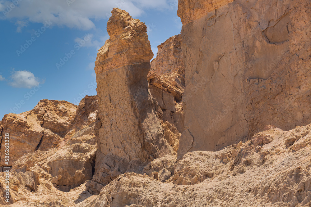 Rock salt column on Mount Sodom on coast of Dead Sea in Israel. Traditionally perceived as petrified wife of Lot. Beautiful landscape with mountains against the blue sky. Landscape of the desert