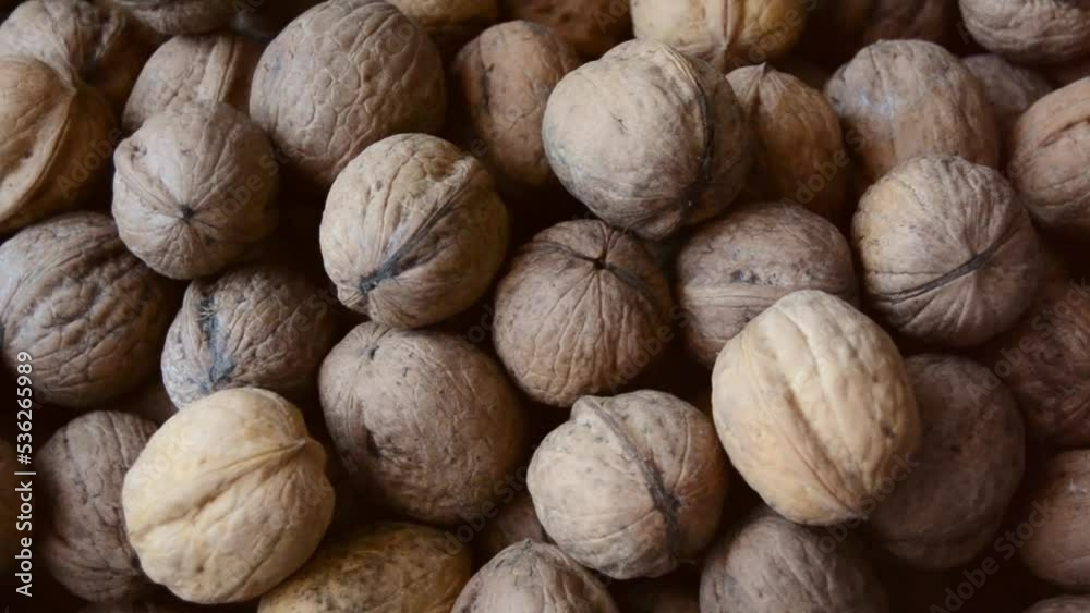 Close up of fresh whole walnuts rotating top view. Foods rich in nutrients. Concept of healthy food Close up of fresh whole walnuts rotating top view. Foods rich in nutrients. Concept of healthy food