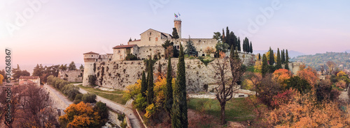 Billede på lærred Super panoramic drone view on charming park with variety of deciduous trees painted in all autumn colors and tall slender cypresses surround the medieval castle in Brescia