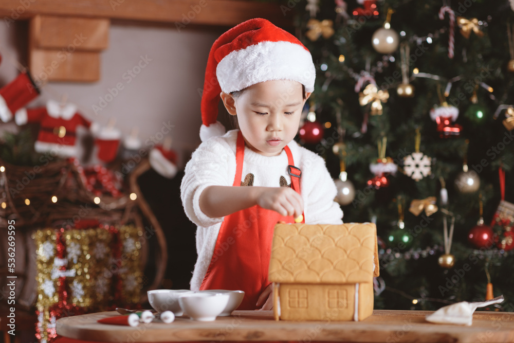 young girl making gingerbread house at home