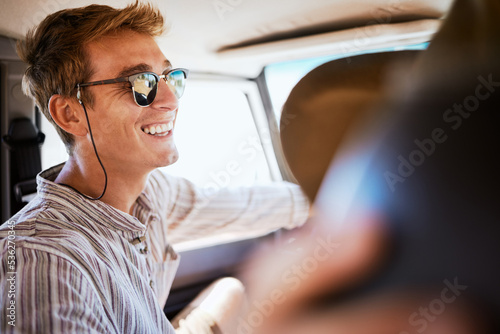 Road trip, friends and man relax in a car, bonding with driver in the passenger seat. Freedom, summer and adventure with smiling man enjoying vacation and drive in city, laughing, joking and cheerful