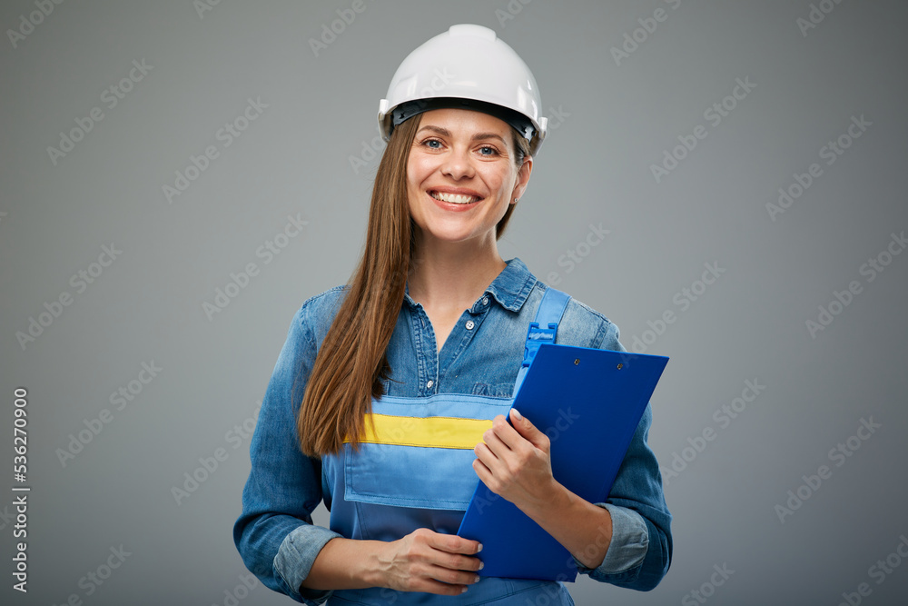 Smiling woman architect or engineer wearing safety helmet and overall holding clipboard. Isolated female portrait. Smiling woman architect or engineer wearing safety helmet and overall holding clipboard. Isolated female portrait.