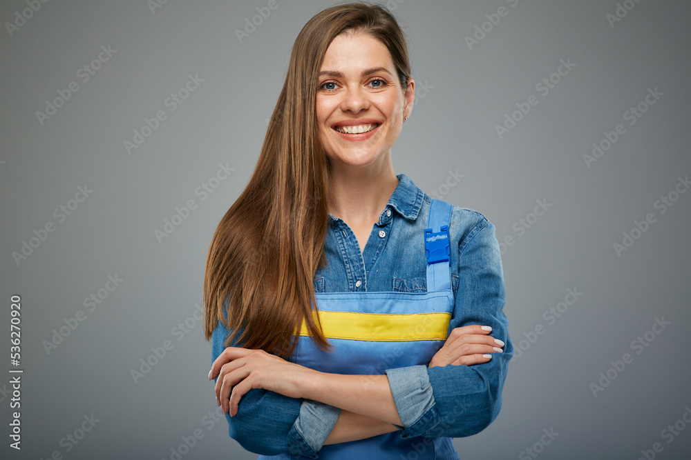 Smiling confident woman builder in blue overalls standing with arms crossed. Smiling confident woman builder in blue overalls standing with arms crossed.