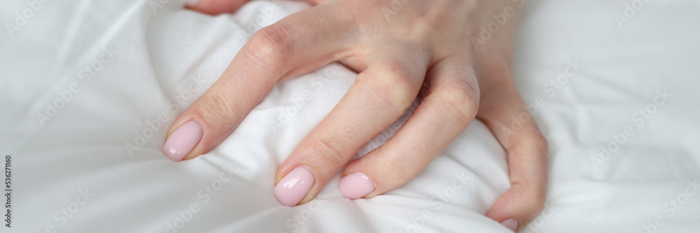 Woman hand squeezing white blanket at home closeup Woman hand squeezing white blanket at home closeup