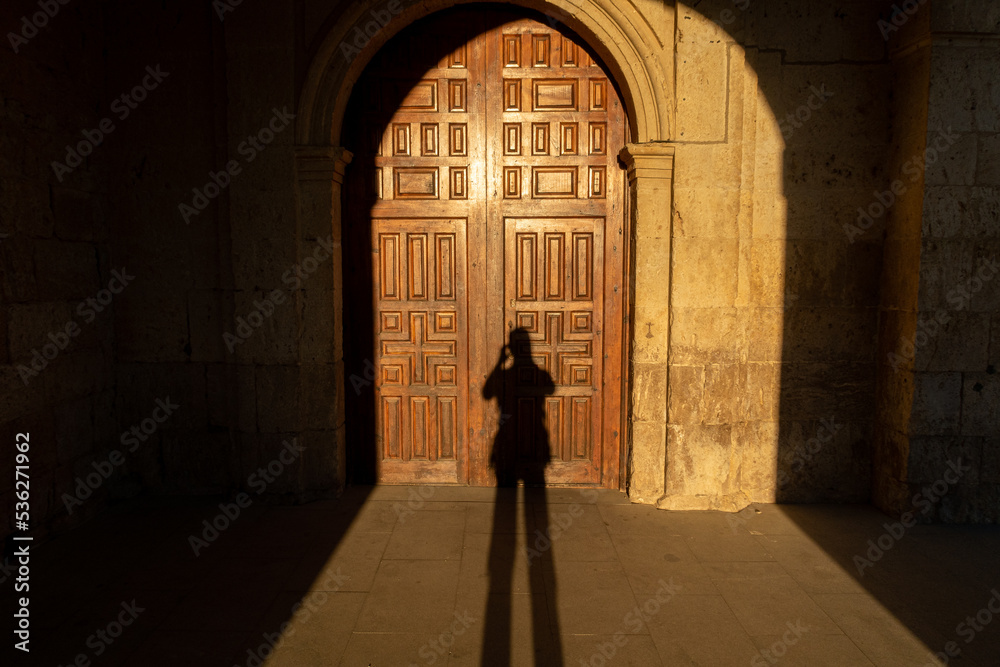 Entrance door to the Church of San Román and silhouette of the photographer. Hornillos del Camino, Burgos, Spain. Santiago's road.