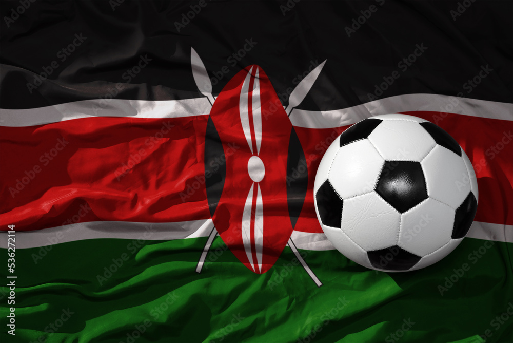 Naklejka premium vintage football ball on the waveing national flag of kenya background. 3D illustration