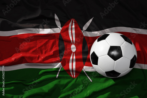 vintage football ball on the waveing national flag of kenya background. 3D illustration