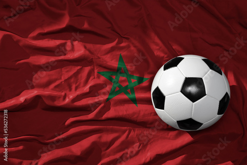 vintage football ball on the waveing national flag of morocco background. 3D illustration
