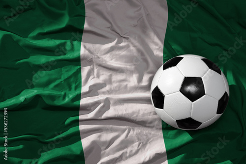 vintage football ball on the waveing national flag of nigeria background. 3D illustration