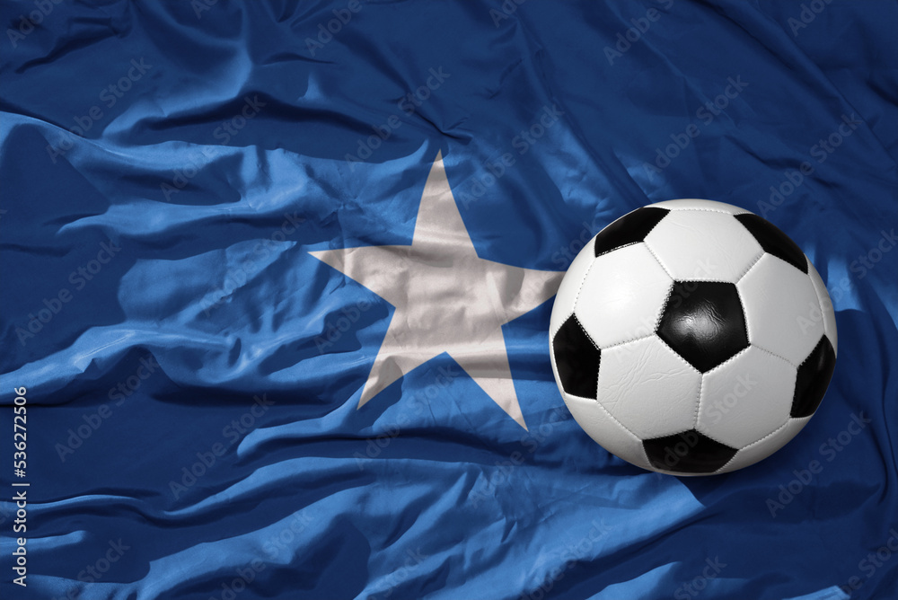Naklejka premium vintage football ball on the waveing national flag of somalia background. 3D illustration