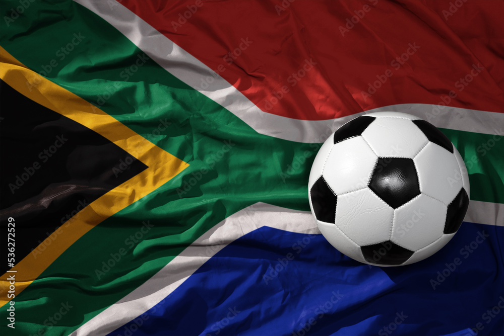 Naklejka premium vintage football ball on the waveing national flag of south africa background. 3D illustration