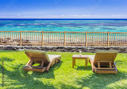 chaises longues sur terrasse avec vue sur lagon paradisiaque 
