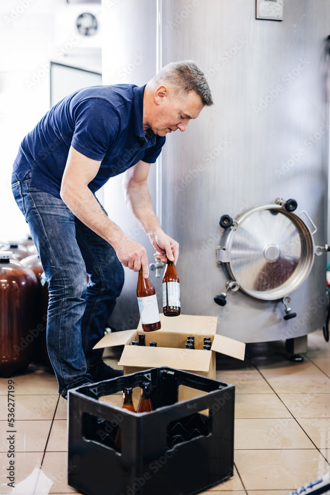 Man preparing craft beer from brewery for shipment. Man preparing craft beer from brewery for shipment.