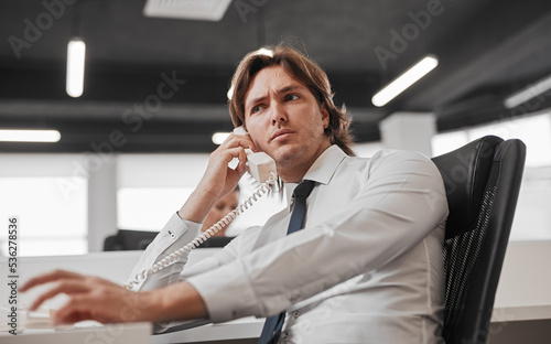 Troubled office worker speaking on phone