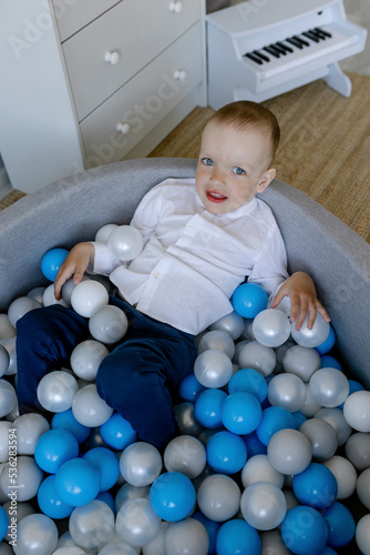 Little boy plays with the children's pool. Plastic balls for an active child.