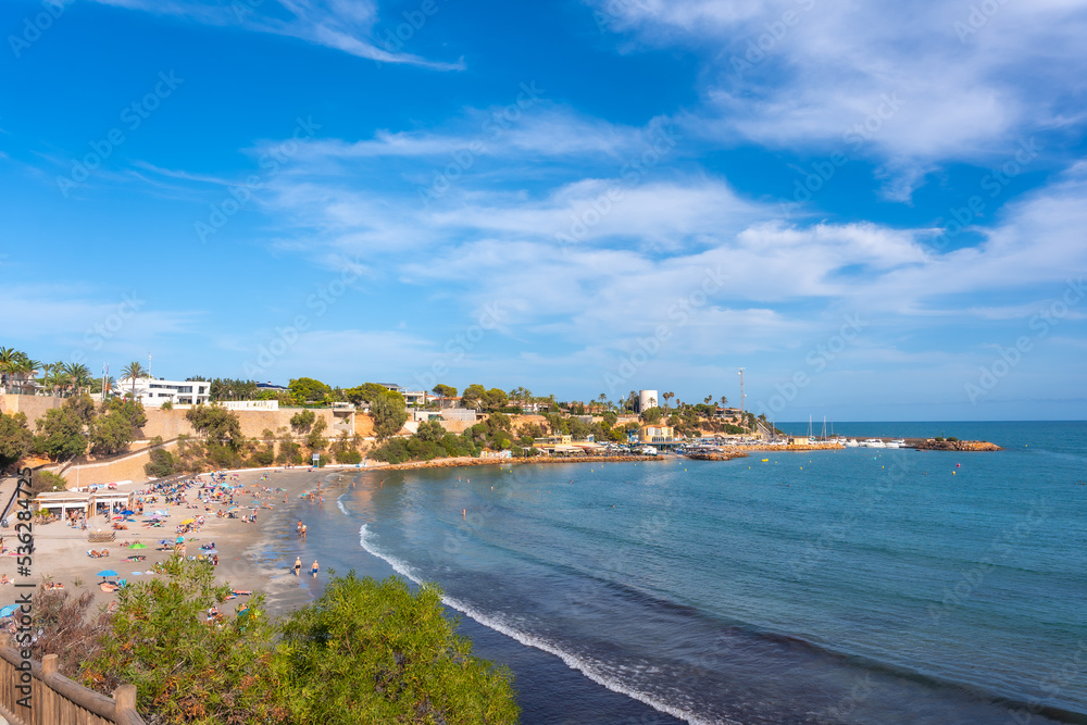 La Caleta beach full of tourists in the tourist town of Cabo Roig. Alicante