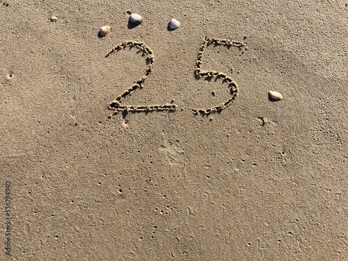 On the beach in the sand is carved the number 25 © Marcus