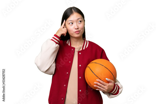 Young basketball player asian woman over isolated background having doubts and thinking © luismolinero