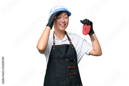 Young caucasian woman wearing an apron and serving fresh cut meat over isolated background smiling a lot
