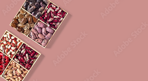 Foto Two sets of organic beans in a wooden boxes on a pink background