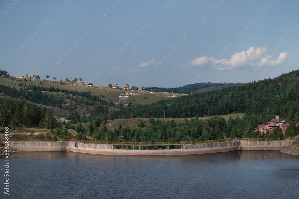 Scenic aerial view of lake dam with forest in background on Zlatibor mountain, Serbia 07.09.2022