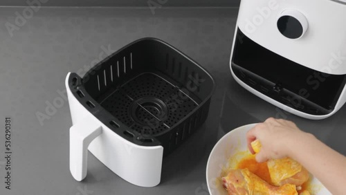 White air fryer. Woman cooking chicken modern technology domestic kitchen