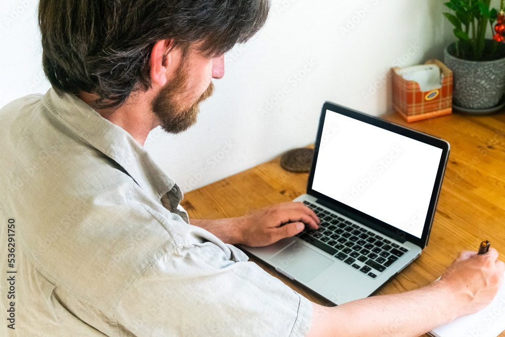 bearded man is working on a laptop. Laptop screen mockup. Selective focus bearded man is working on a laptop. Laptop screen mockup. Selective focus